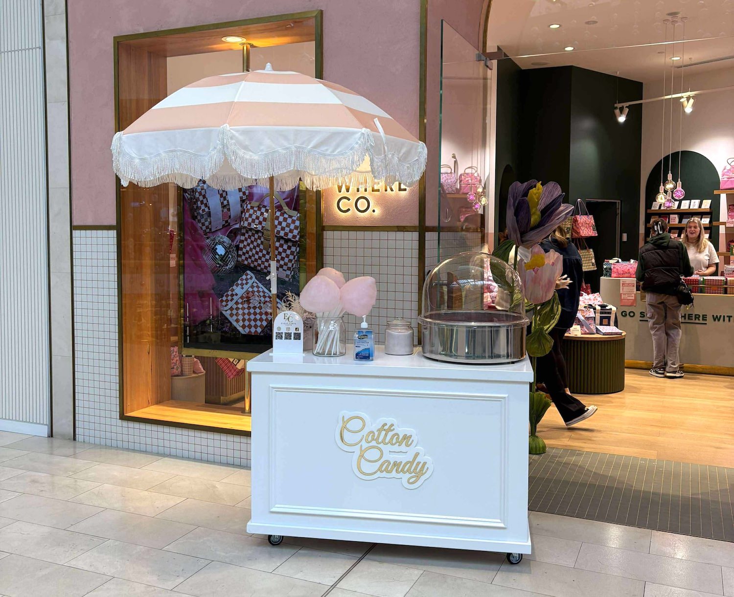 Cotton candy cart with white fringed parasol, spinning machine and gold lettering