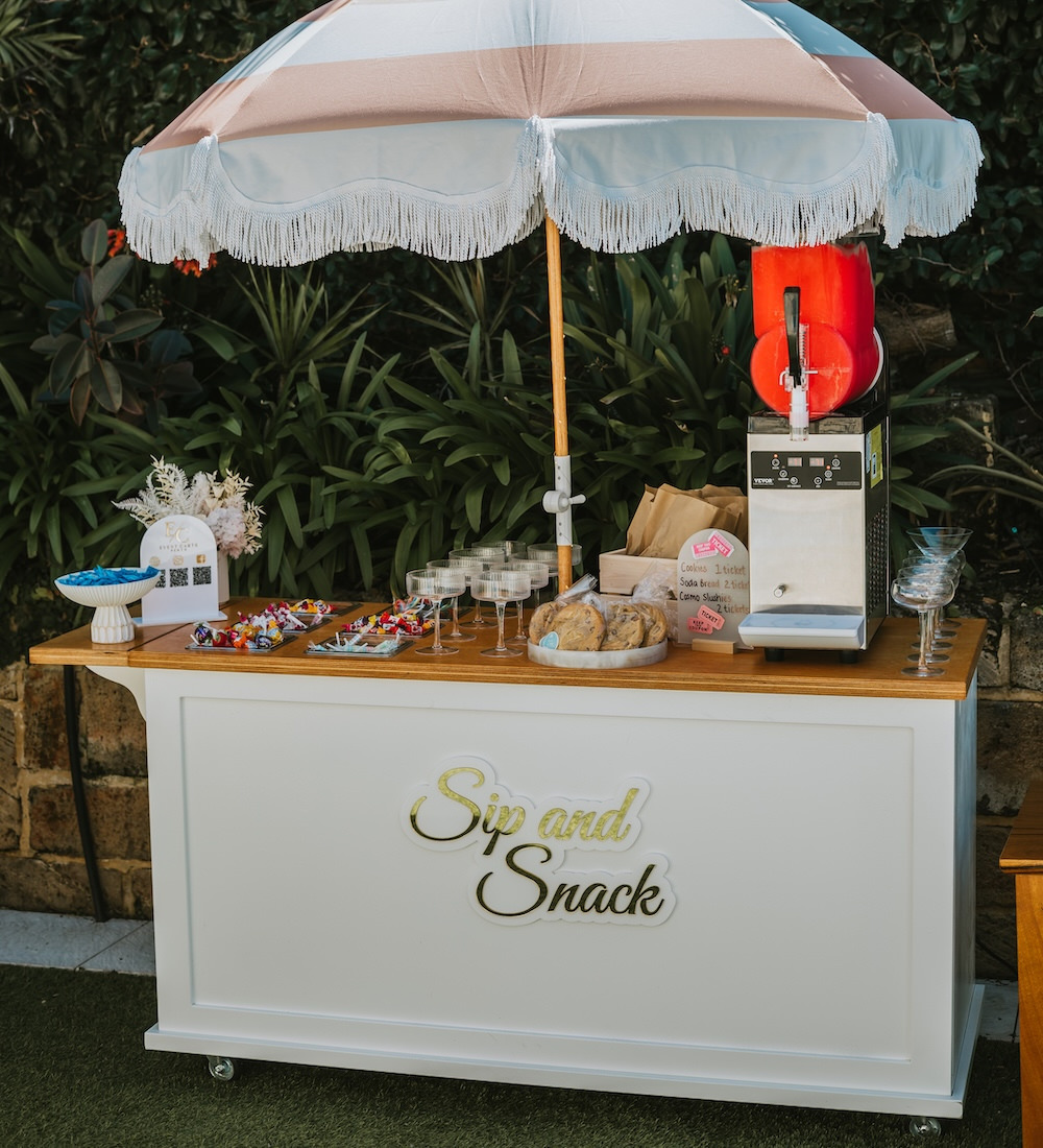 Sip and Snack cart with fringed parasol, timber top, and gold lettering