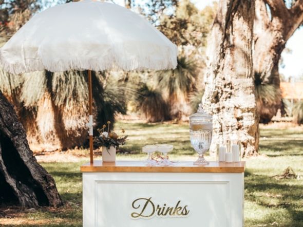 White drinks cart with fringed umbrella