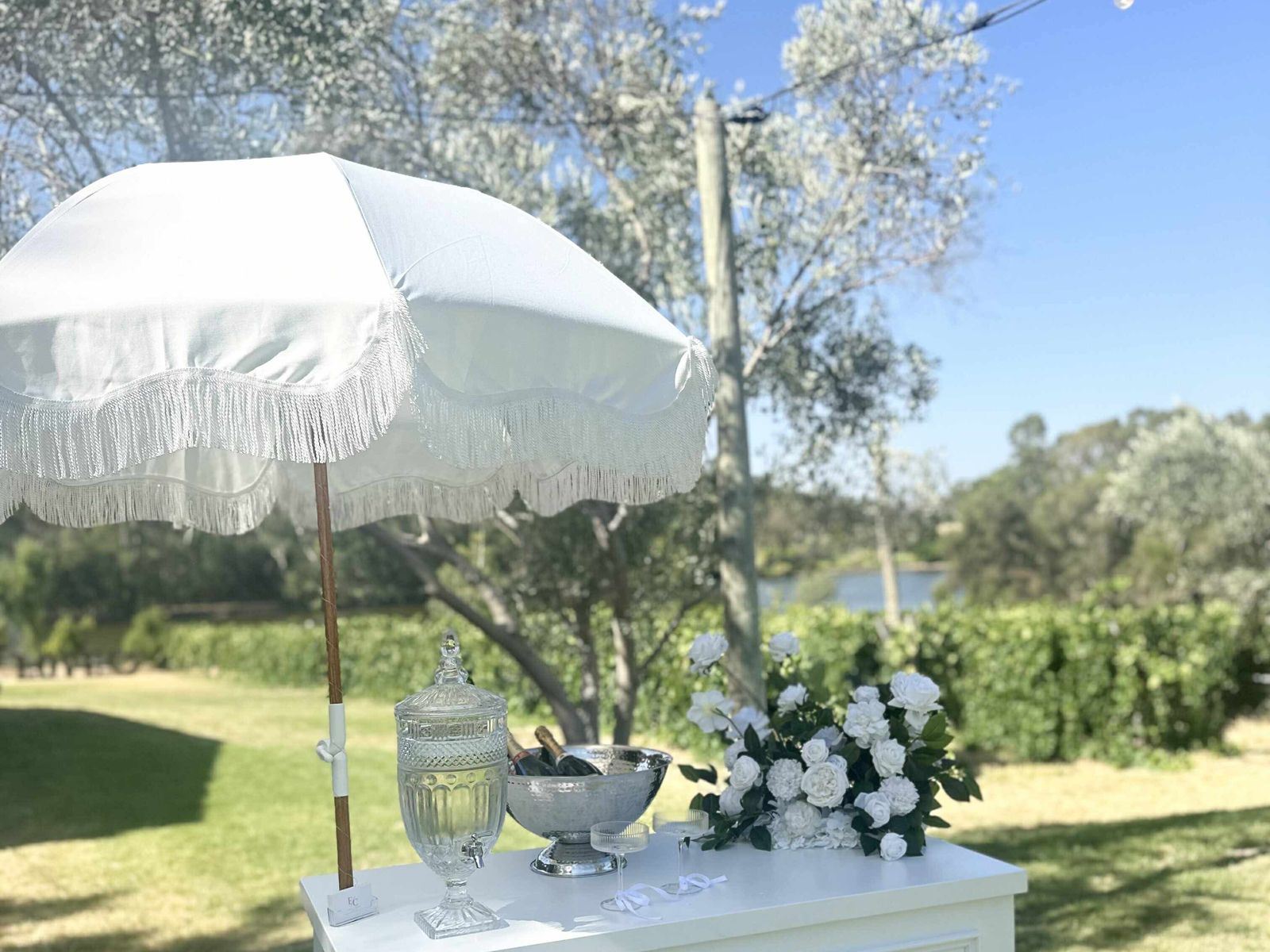 White event cart styled with flowers and champagne at a vineyard setting