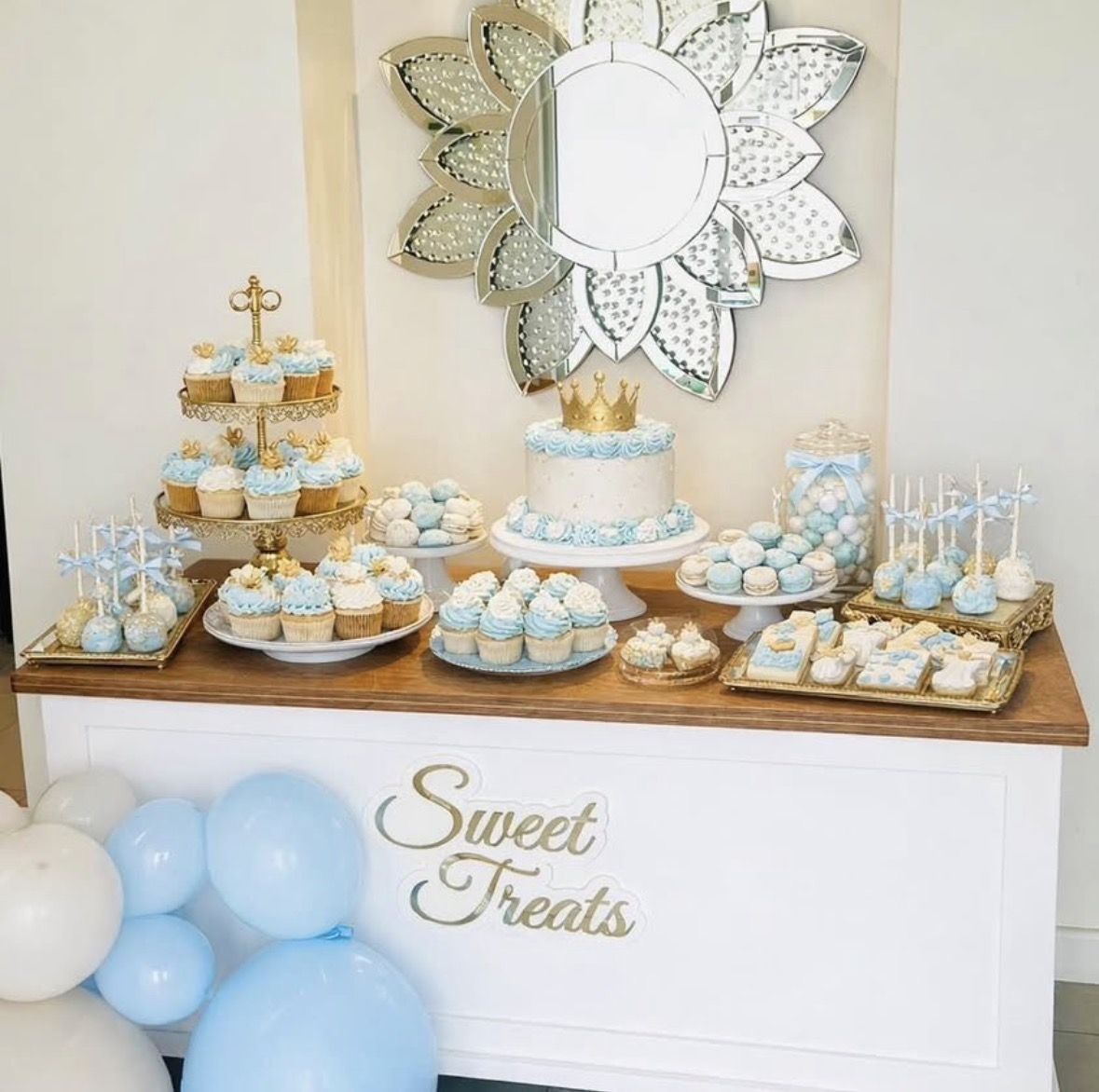 Sweet treats cart styled with cupcakes, cake, and blue balloons